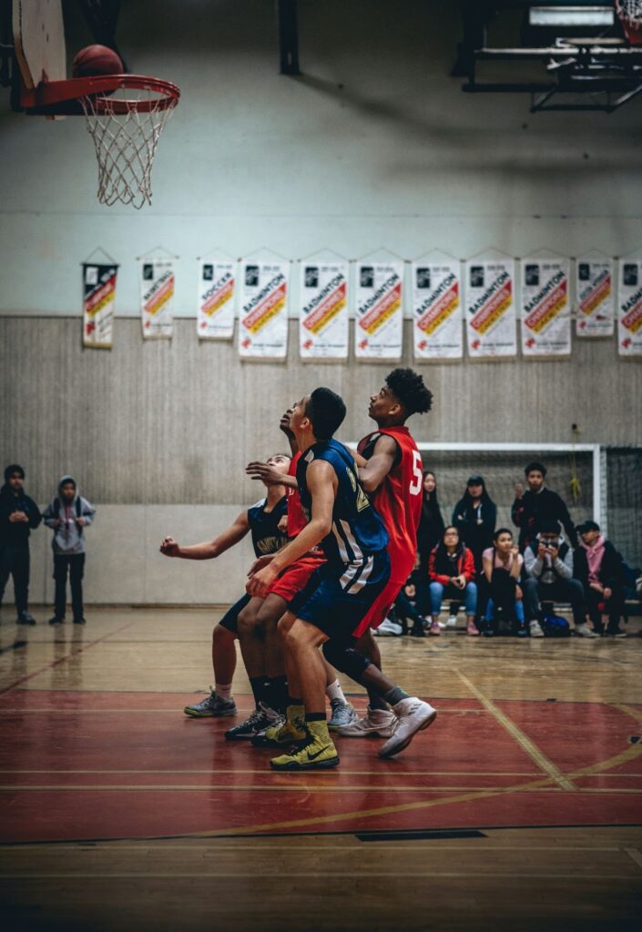 Young basketball players playing on an indoor court.