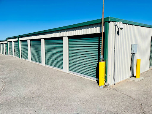 A mini storage building with green doors. 